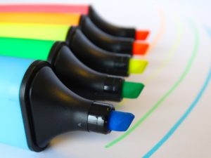 A line of open highlighters in a rainbow pattern